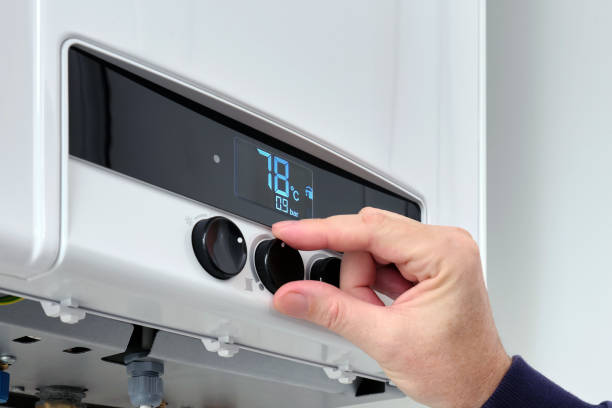 istock A man sets the temperature on a modern digital gas boiler in a house. 2178736554