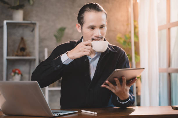 istock Businessman are sitting and happy at cafe. Man using internet and technology by tablet, laptop and smartphone for business, working, communication, studying and job. 2178736620
