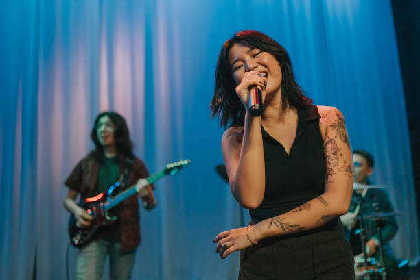 istock Young Asian chinese lead singer and live band Multiracial group performance on stage 2178742712