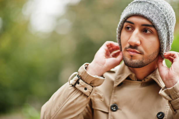Stylish kuwaiti man at trench coat and hat.