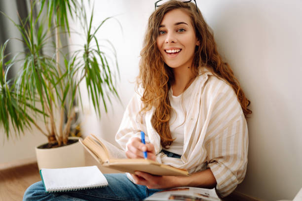 istock Young woman reading interesting book at home. 2178749152