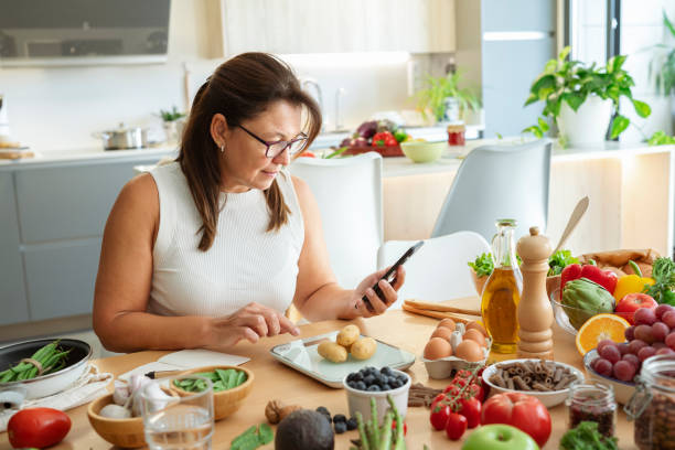 istock Woman in kitchen using weight scale to plan well balanced diet. 2178751959
