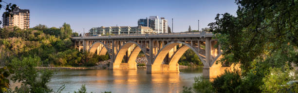 The iconic Broadway Bridge spans the Saskatchewan River in downtown Saskatoon, connecting the city with scenic views of the water and skyline
