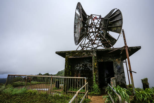 A weathered radar station stands atop a mist-covered mountain, adding a sense of rugged isolation and historical intrigue.