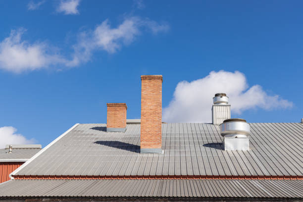 Lockhart, Texas, United States. Brick chimney and vents on a metal roof.