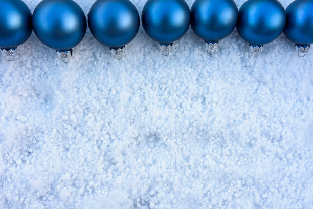 blue christmas balls in a row on snow. Christmas card concept