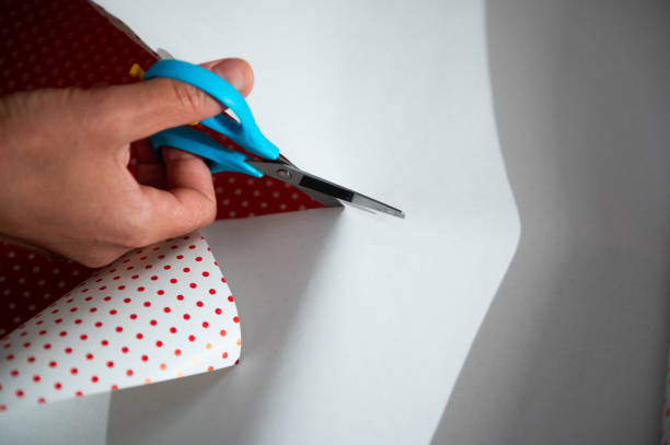 istock Cutting wrapping paper with blue scissors creating polka dot gift wrap during holiday season 2178764989
