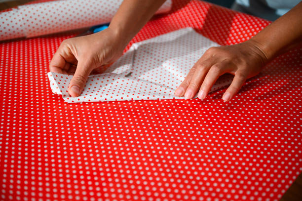 istock Hands carefully folding polka dot wrapping paper in preparation for gift wrapping, creating a beautifully wrapped present with precision and attention to detail for a special occasion or event. 2178765010