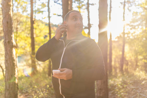 istock Plus size men putting wireless headphones, walking trough the forest and connecting with a nature. 2178766205