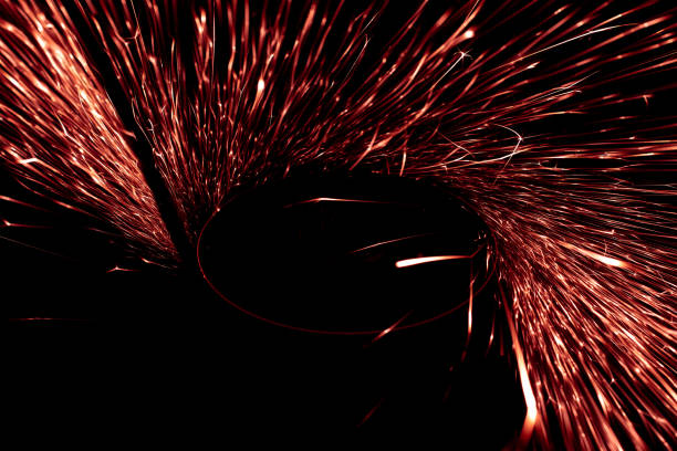 red sparks from the grinder glowing in the dark