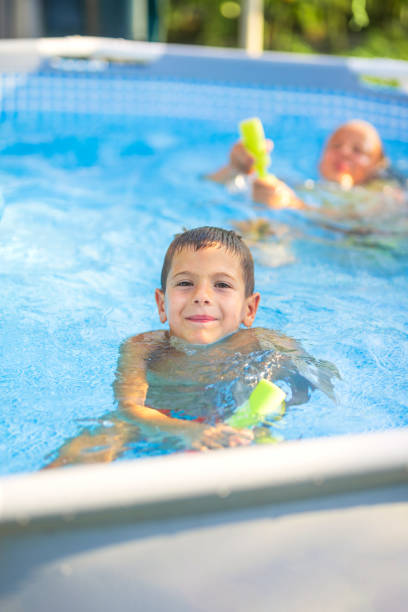 istock Boy smiling and playing in swimming pool on summer day 2178770196