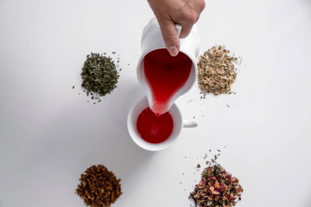 White cup of tea with various tea leaves, shot from above