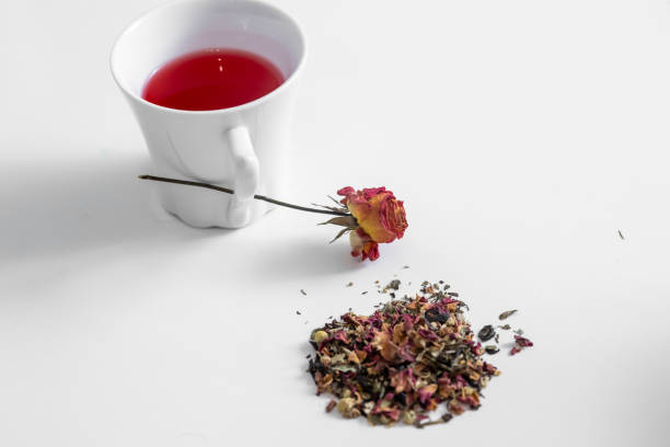 White cup with red tea with mixed dried leaves - hibiscus, rose, rosehip