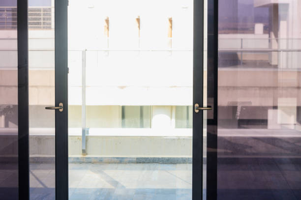 istock A Sunlit Moment Captured Through Glass Doors, Showcasing a Modern Urban Balcony With Bright Reflections and Subtle Shadows 2178774826