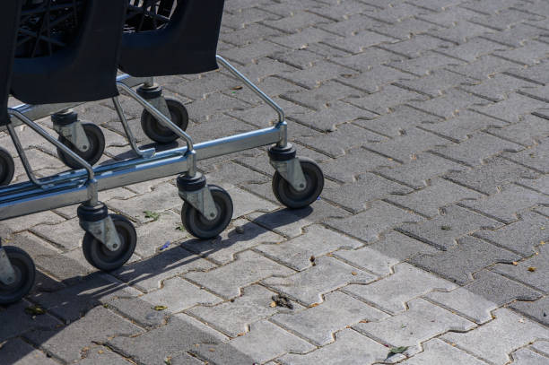istock Shopping carts lined up on a paved sidewalk under bright sunlight during a busy morning at a retail location 2178774863