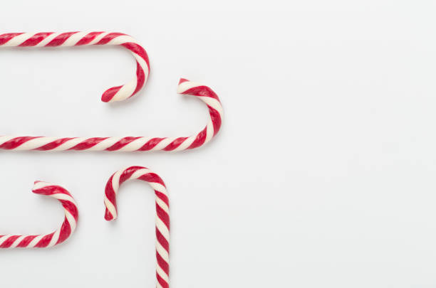 Candy cane Christmas decor with copy space. Gray background and snow.