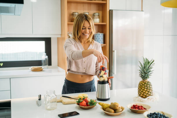 istock Woman Blending Fresh Fruits for a Smoothie in Modern Kitchen 2178778937