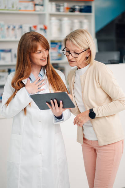 istock Young druggist with tablet having consultations with senior woman. 2178779063