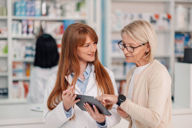 istock Friendly pharmacist helping senior customer choosing prescription using digital tablet in pharmacy 2178779066