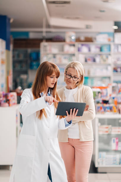 istock Friendly pharmacist showing information on digital tablet to customer in drugstore 2178779075