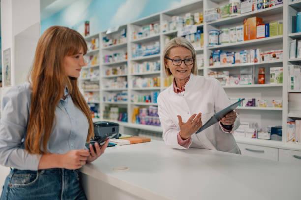 istock Friendly female senior pharmacist with tablet giving advice to patient 2178779094
