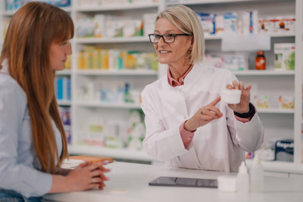 istock Professional old druggist with creme in hands selling it to a customer 2178779097