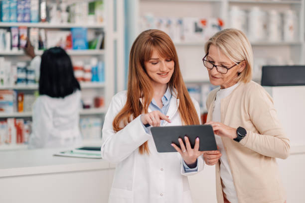 istock Friendly pharmacist showing information on tablet to customer 2178779099