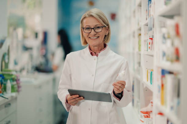 istock Senior pharmacist holding medicine and using digital tablet in pharmacy 2178779136