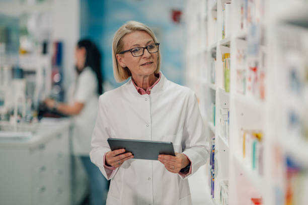 istock Senior female pharmacist using digital tablet, managing inventory in pharmacy 2178779140
