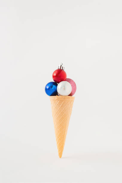 Ice cream cone with chroistmas decorations on white background. Christmas food idea.