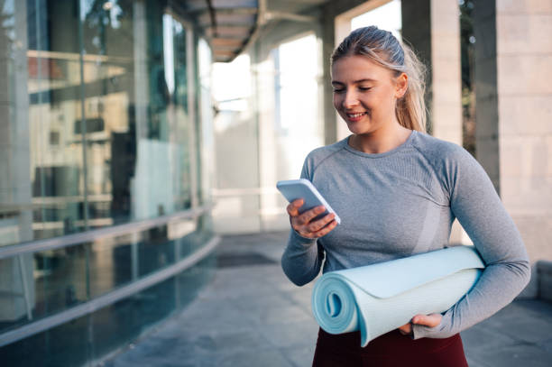 istock Young sporty woman using smartphone app before workout outdoors 2178780641