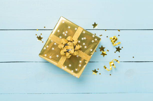 istock Golden gift boxes and confetti on wooden background, top view 2178782492