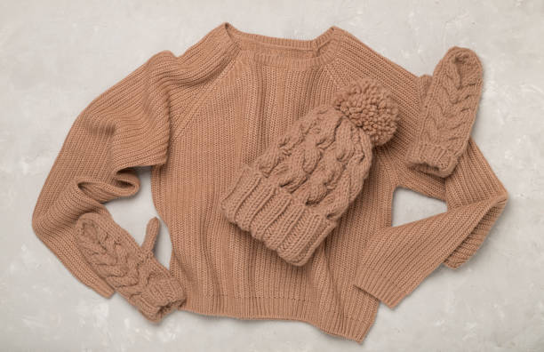 istock Sweater and winter hat with mittens on concrete background, top view. 2178783341