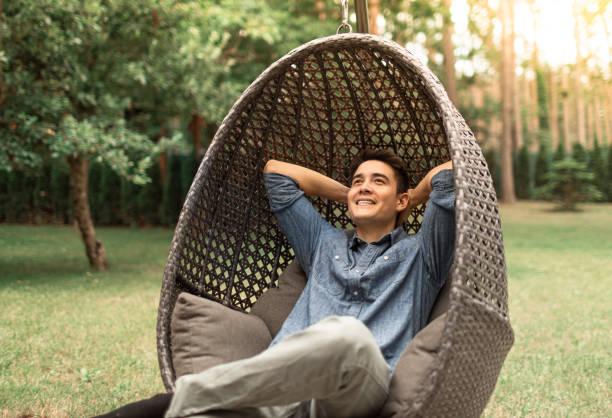 istock Young man relaxing sitting in comfortable chair in outdoor setting enjoying weekend, quiet time in nature. 2178784814