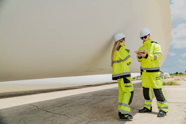 istock Two engineers inspect a massive wind turbine blade at a construction site. The image showcases the scale of wind power projects and the detailed work involved in renewable energy development. 2178795959