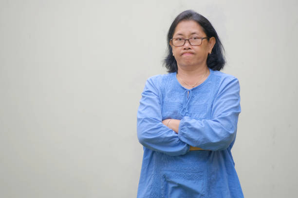 istock Woman standing alone folding her hands with disappointed facial expression 2178797351