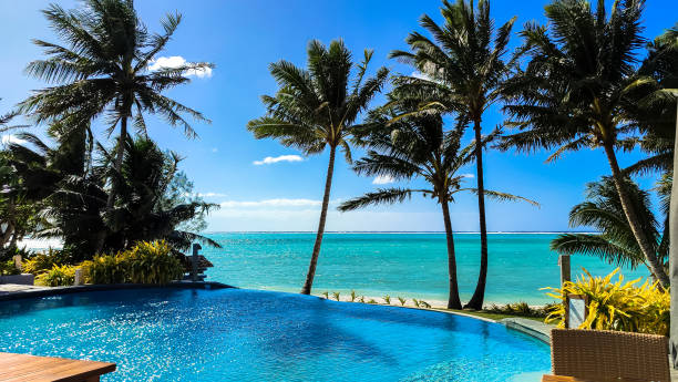 istock Tranquil lagoon stretches towards the horizon, fringed by swaying palm trees. Infinity pool seamlessly blends with the turquoise water. Cook Islands: ultimate serenity, idyllic escape. 2178797795