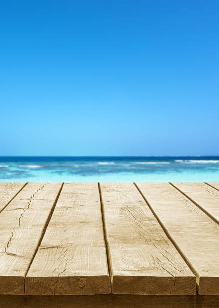 istock Empty wooden table top with beautiful turquoise sea and sunny blue sky background 2178799375
