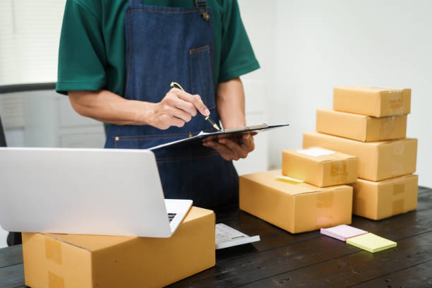 istock A man is working at his desk, preparing parcel boxes for shipment. He checks and packs items carefully, using shockproof materials, and attaches labels before sending them to customers via EMS. 2178803542