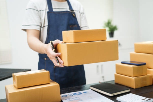 istock A man is working at his desk, preparing parcel boxes for shipment. He checks and packs items carefully, using shockproof materials, and attaches labels before sending them to customers via EMS. 2178803548