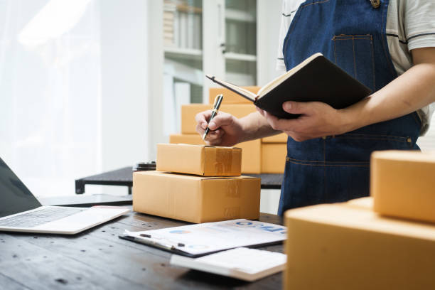 istock A man is working at his desk, preparing parcel boxes for shipment. He checks and packs items carefully, using shockproof materials, and attaches labels before sending them to customers via EMS. 2178803553