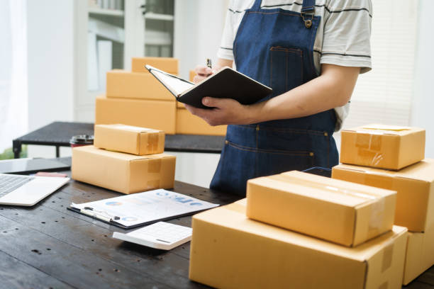 istock A man is working at his desk, preparing parcel boxes for shipment. He checks and packs items carefully, using shockproof materials, and attaches labels before sending them to customers via EMS. 2178803556
