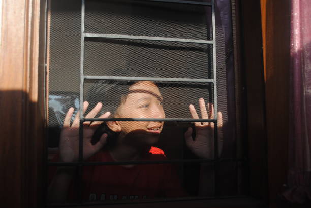 Happy teenager looking out through the window.