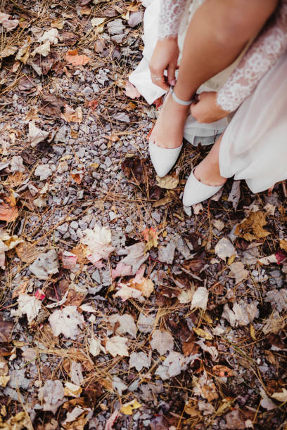 istock Bride putting on shoes in wedding dress outdoors with copy space 2178807010