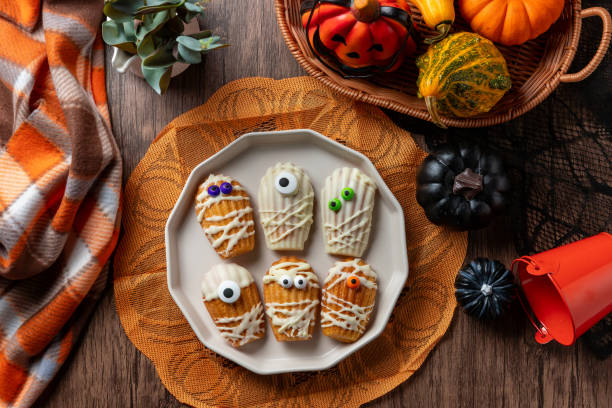 istock White Chocolate Dipped Mummy Madeleines on wooden table. 2178807544