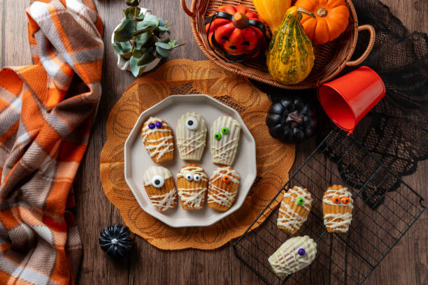 istock White Chocolate Dipped Mummy Madeleines on wooden table. 2178807545