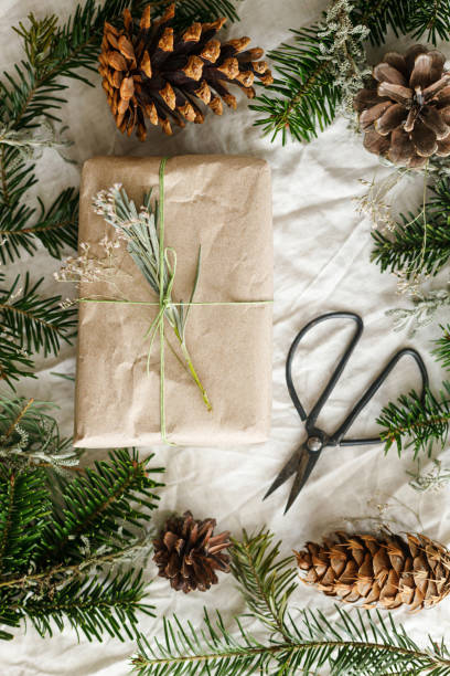 istock Stylish zero waste gift on rustic table with fir branches and pine cones flat lay. Merry Christmas! Modern simple wrapped gift box with fir branches and natural ornaments 2178808014
