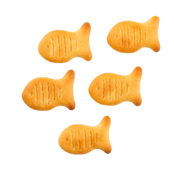 Fish-shaped cracker cookies on a white background. Fish-shaped cracker cookies on a white background. Crispy crackers isolated. goldfish snack stock pictures, royalty-free photos & images