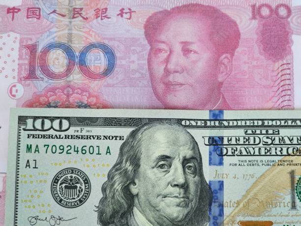 istock Comparison of Chinese Yuan and US Dollar notes featuring Mao Zedong and Benjamin Franklin 2178815548
