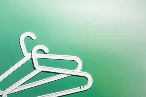 istock Two White Clothes hangers, contemporary minimal composition on vivid green gradient background, Plastic rack creating modern and minimal aesthetic, top view, flat lay creative photo, copyspace 2178815885
